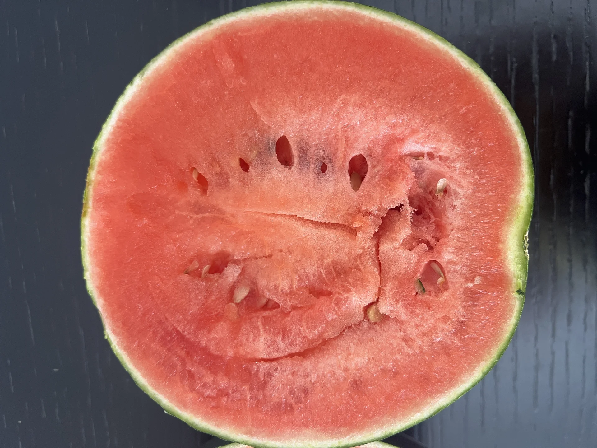 A watermelon cut in half, showing the sweet red flesh and dark seeds inside
